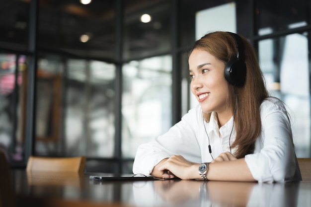 mujer relajante escuchando canciones con auriculares y teléfonos inteligentes.