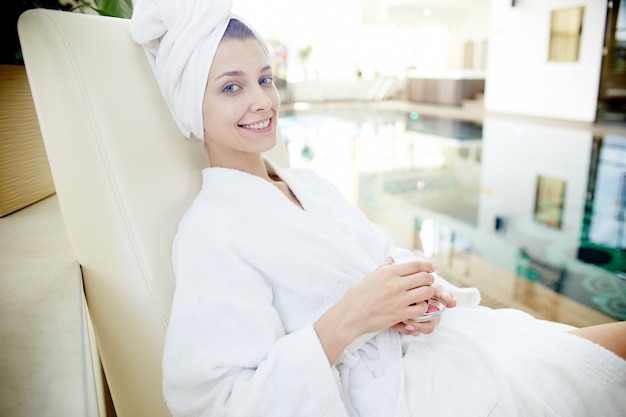 Mujer relajante junto a la piscina en spa