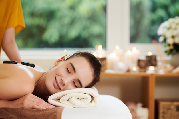 Mujer relajante con piedras