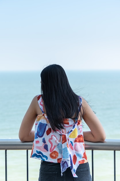 Mujer relajarse en el punto de vista del mar en concepto de viaje