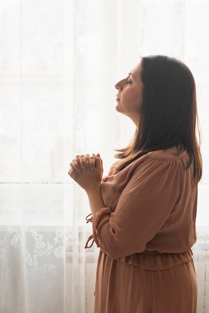 Foto mujer religiosa rezando en casa