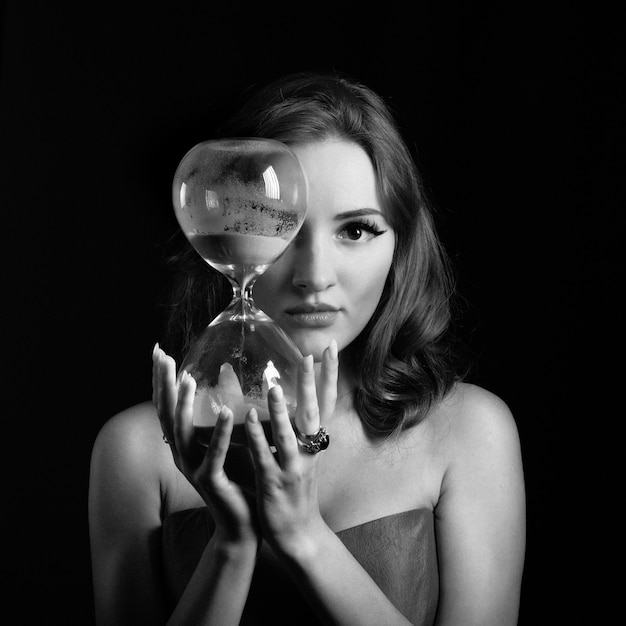 Mujer con relojes de arena rodada en blanco y negro