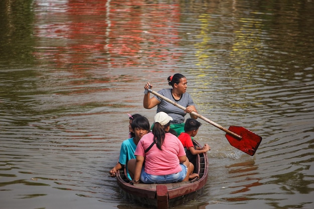 Una mujer remando un barco con una paleta que dice "no".