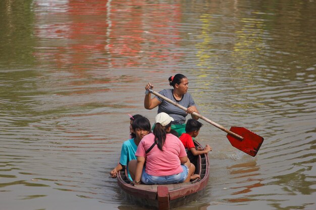 Una mujer remando un barco con una paleta que dice "no"