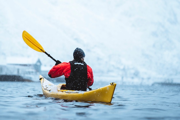 Mujer remando un kayak en Lofoten, Noruega