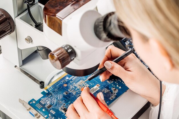 Mujer reparando hardware de computadora en el centro de servicio Servicio de reparación y reparación en el laboratorio Concepto de servicio de reparación de electrónica