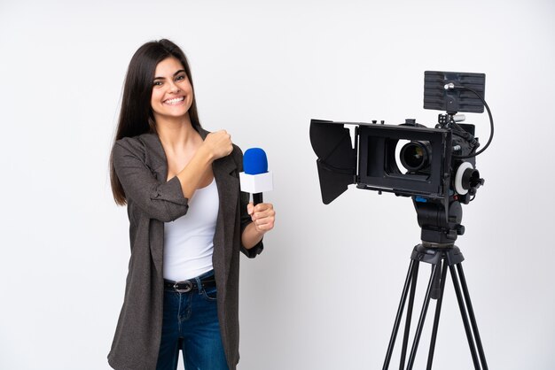 Mujer reportera sosteniendo un micrófono y reportando noticias celebrando una victoria