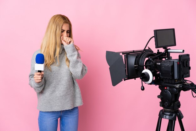 Mujer reportera sosteniendo un micrófono y reportando noticias sobre tos rosado aislado mucho