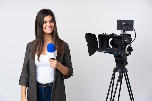 Mujer reportera sosteniendo un micrófono y reportando noticias