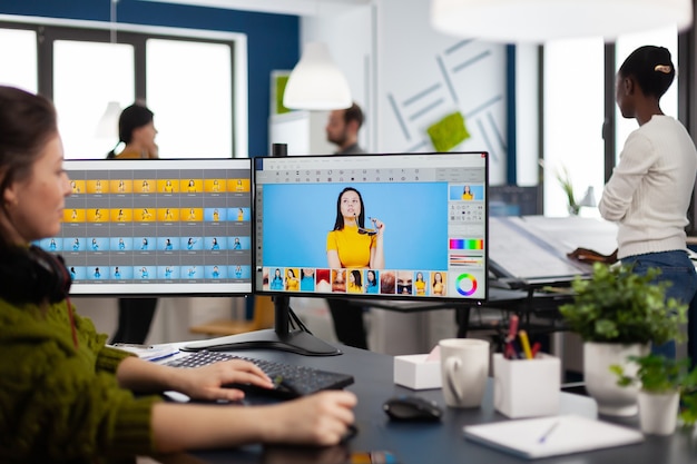 Mujer de retocador autónomo que trabaja en la computadora con software de edición de fotos