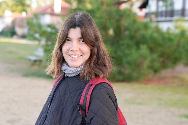 Mujer de retrato de mediana edad al aire libre en el parque de otoño de invierno