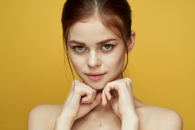 Mujer con retrato de piel hermosa con sonrisa sobre fondo amarillo