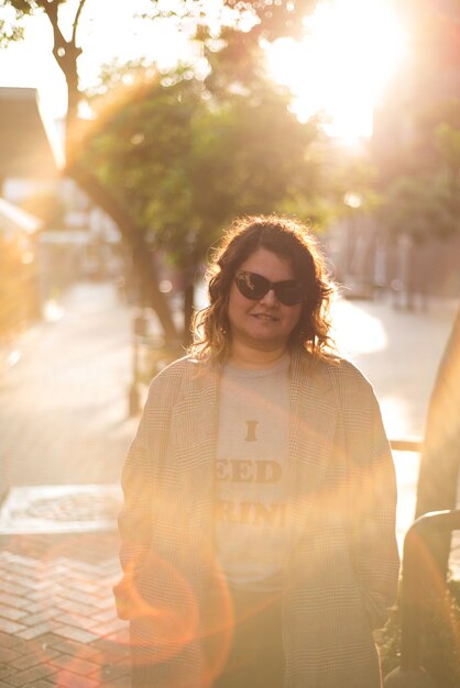 Mujer retroiluminada con rayos de sol en la calle Espacio de copia de imagen urbana