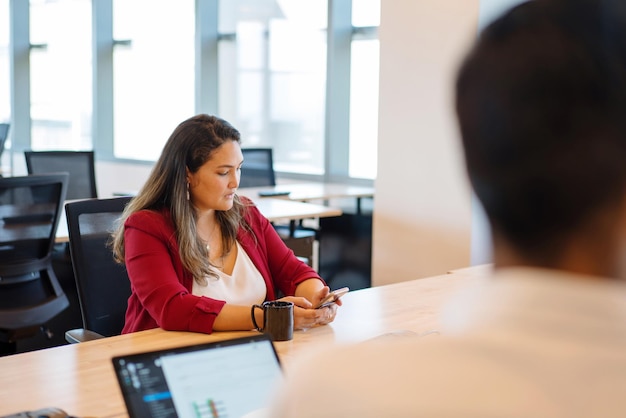 Foto mujer en la reunión en la oficina usando el teléfono