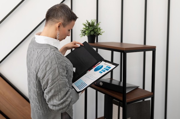 Mujer revisando documentos en una carpeta en una oficina elegante