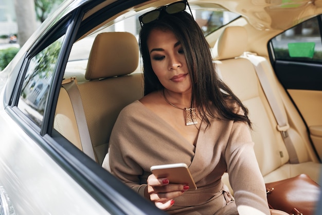 Mujer revisando a los mensajeros en el coche