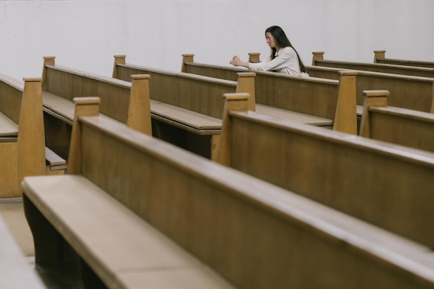 Mujer rezando a Dios en la iglesia