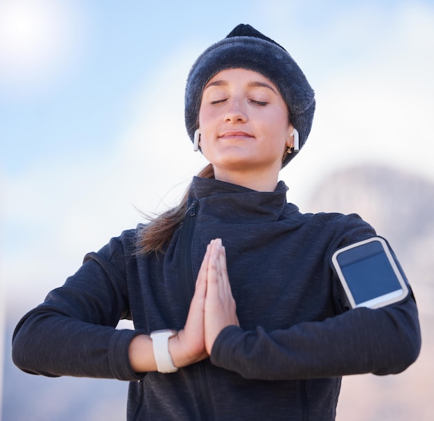 Mujer rezando con las manos y entrenando en Park City o concéntrese en la respiración de meditación y comience el ejercicio matutino Gen z runner girl smartphone y al aire libre con paz para la salud y el bienestar de la atención plena