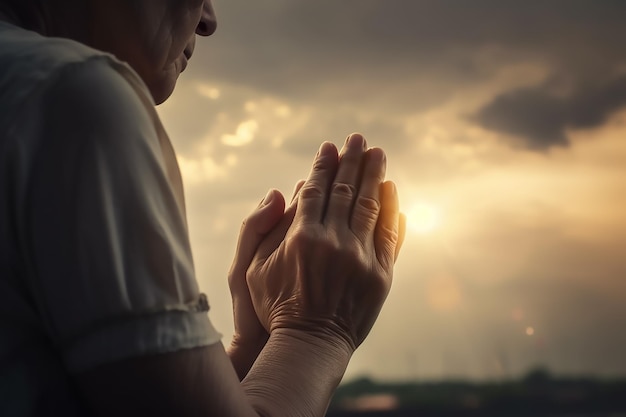 Una mujer rezando con el sol detrás de ella.