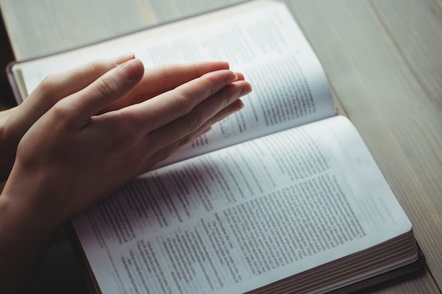 Mujer rezando con su biblia