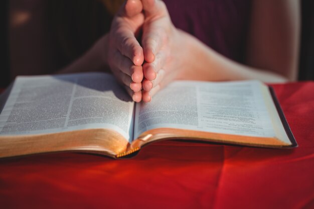 Mujer rezando con su biblia