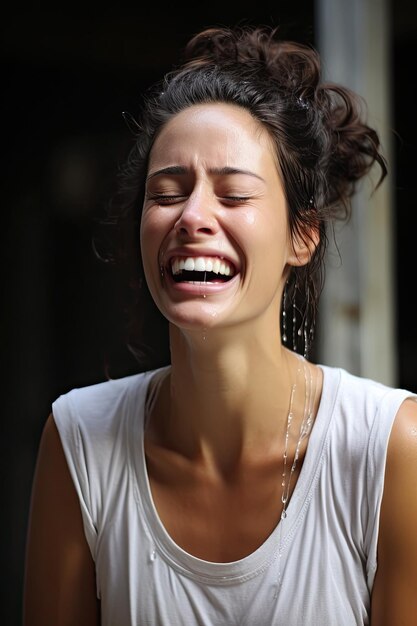 una mujer riendo con agua goteando de su cara