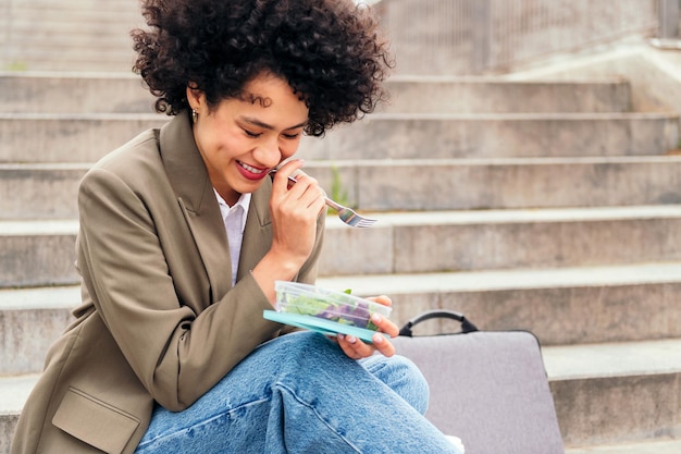 Mujer riendo y comiendo durante un descanso del trabajo