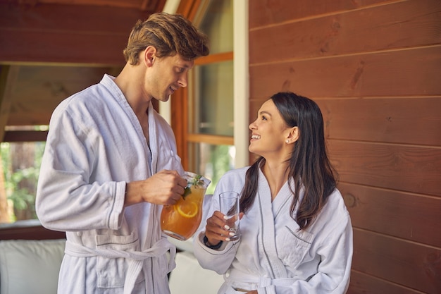 mujer riendo y hombre guapo con limonada naranja mirando el uno al otro