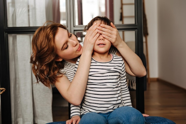 Foto mujer rizada sorprende a su hija y cierra los ojos