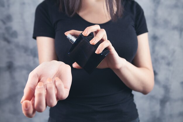 Mujer rocía perfume en su mano