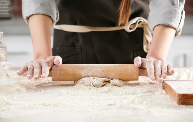 Mujer rodando masa para pasta en primer plano de la mesa