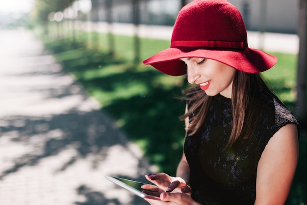 Mujer, rojo, sombrero, controles, ella, tableta, sentado, afuera