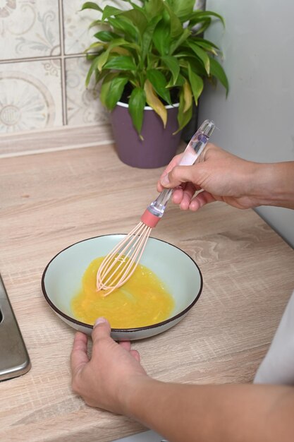 Foto mujer rompe huevos para hacer una tortilla