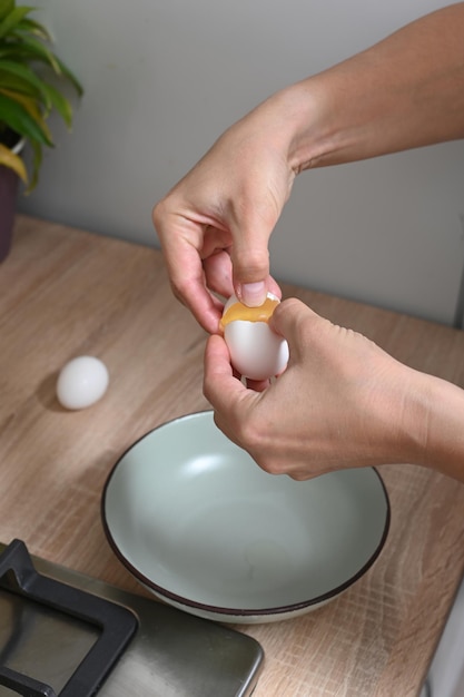 Foto mujer rompe huevos para hacer una tortilla