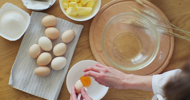 Foto mujer rompiendo un huevo en harina para hacer pan según la receta tradicional mujer horneando en casa disfrutando de un hobby