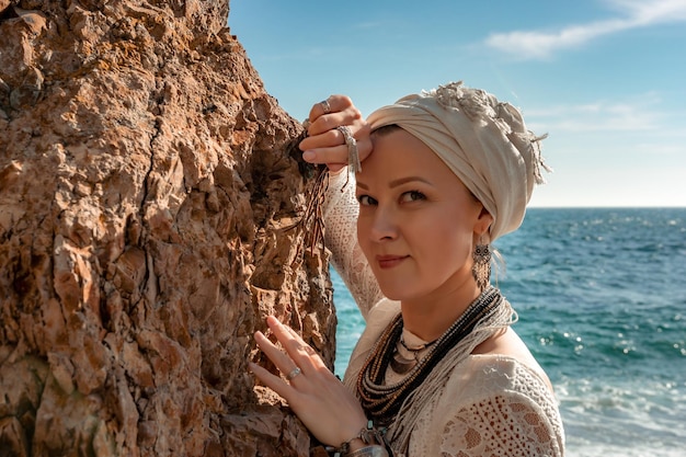 Mujer con ropa bohemia en la playa al atardecer estilo boho para un look moderno en el resort de mediana edad