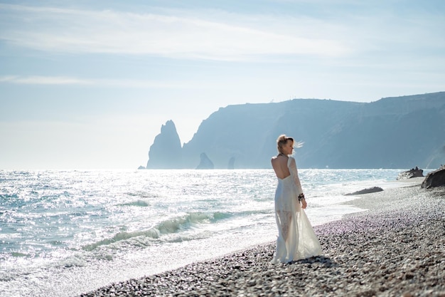 Mujer con ropa bohemia en la playa al atardecer estilo boho para un look moderno en el resort de mediana edad