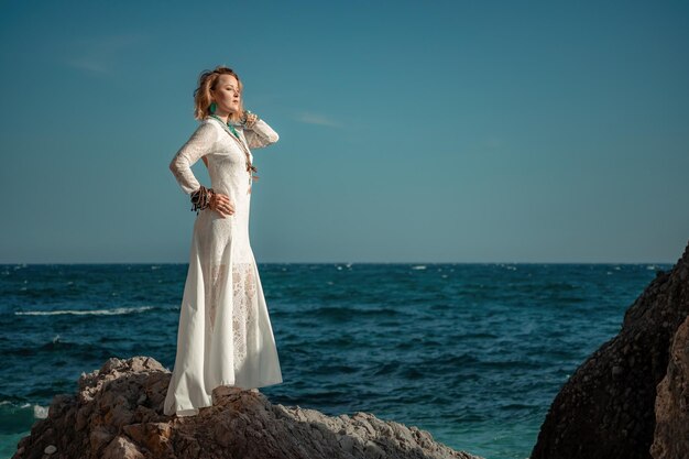 Mujer con ropa bohemia en la playa al atardecer estilo boho para un look moderno en el resort de mediana edad