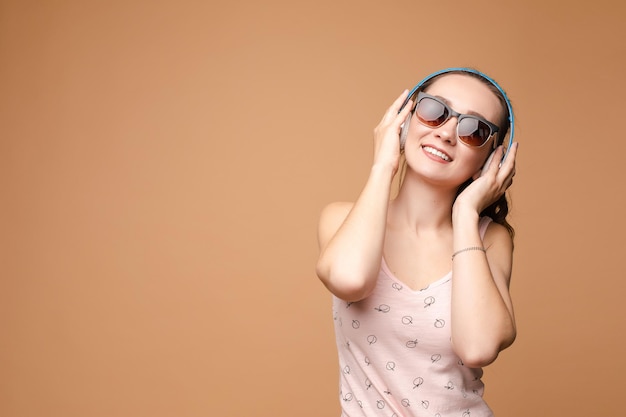 Una mujer con ropa brillante, una camiseta y pantalones cortos de mezclilla, gafas de sol.