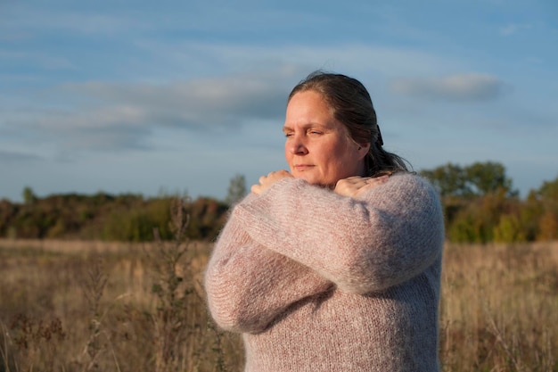 Foto mujer con ropa cálida mirando hacia el cielo