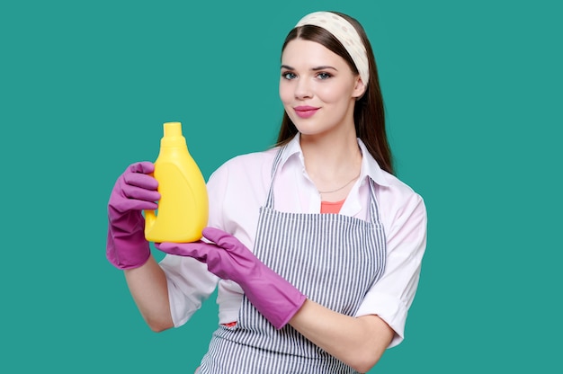 Mujer en ropa casual y guantes de goma con productos de limpieza