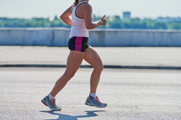 Mujer en ropa deportiva corriendo en la calle