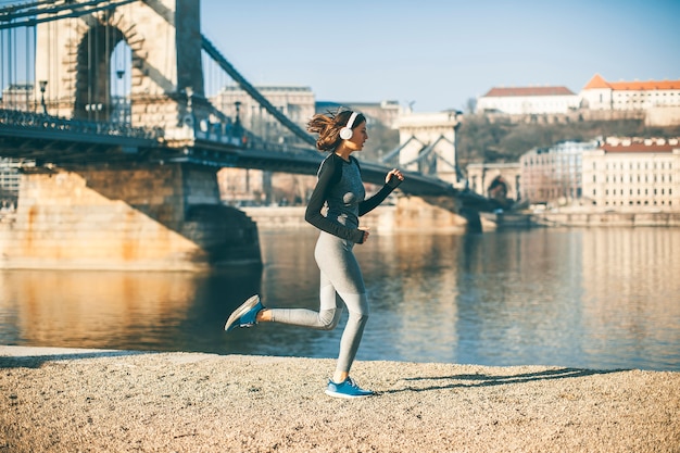 Mujer en ropa deportiva corriendo en el paseo del río Danubio en Budapest