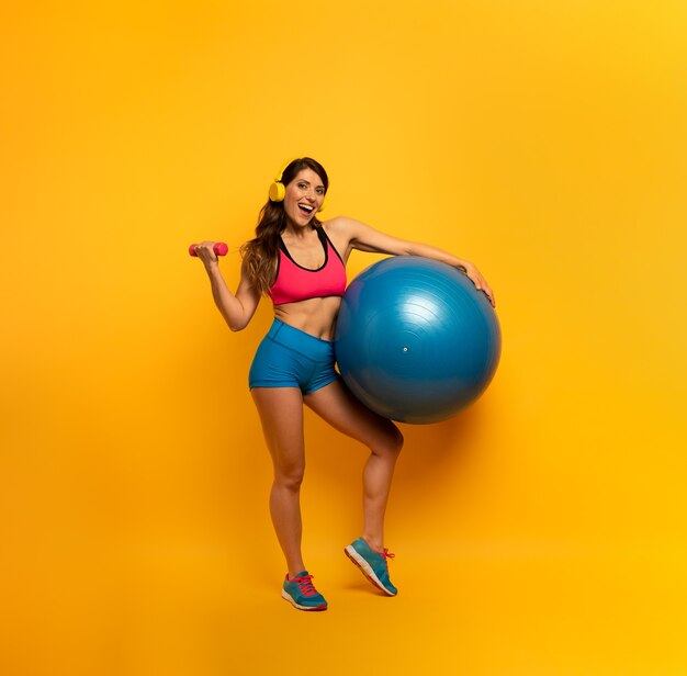 Mujer en ropa deportiva con una pelota de gimnasia