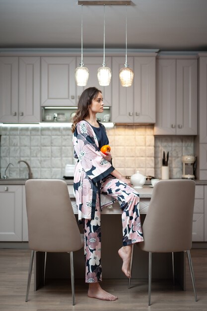 Mujer en ropa de dormir en la cocina