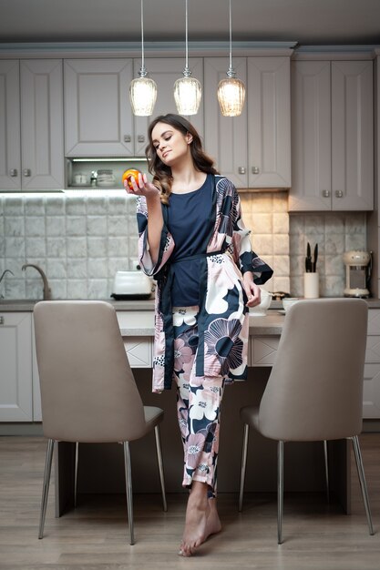 Mujer en ropa de dormir en la cocina