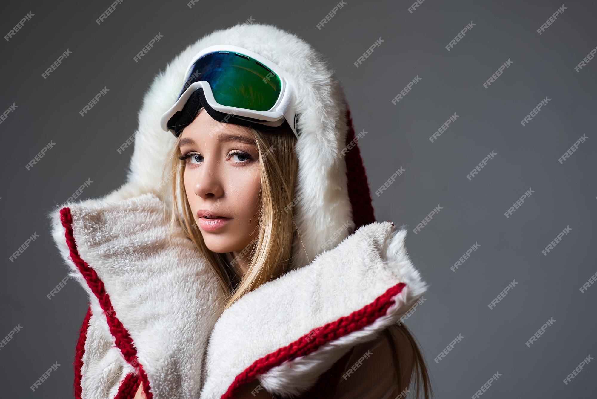 Mujer en ropa de esquí posa con gafas de esquí retrato de niña con gafas de  nieve