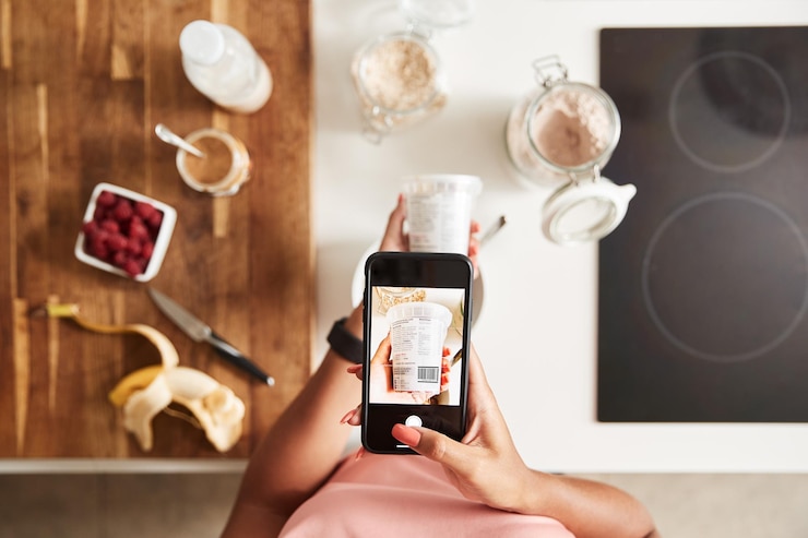 Foto mujer con ropa de fitness escaneando el código qr en los envases de alimentos para encontrar información nutricional