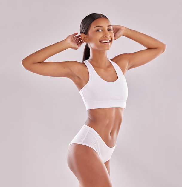 Foto mujer en ropa interior sonríe en retrato con cuerpo y salud física y piel aislada en el fondo del estudio modelo femenino feliz abdomen y estilo de vida saludable con bienestar y persona perder peso