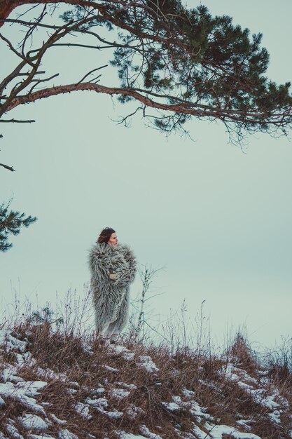 Mujer en ropa de invierno ucraniana histórica abrigo de piel de oveja gunia